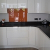 Luxury Handle Less Fitted Kitchen With Solid Worktops & Coloured Glass Splashback